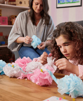 Kassidy, an 11-year-old living with NF1 PN, making paper crafts with an adult